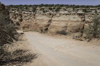 dirt road going through an otherwise arid terrain with a clear blue sky overhead as seen from above the area