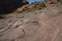 a person on a horse that is in some kind of canyon trail near the mountains