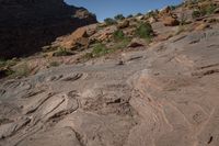 a person on a horse that is in some kind of canyon trail near the mountains