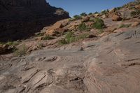 a person on a horse that is in some kind of canyon trail near the mountains