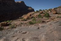 a person on a horse that is in some kind of canyon trail near the mountains