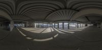 a panoramic image of an airport lobby from inside it with a car park to the side