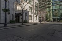 a city street next to a tall white building with several windows and signs on it