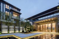 an apartment building with modern lighting and small pool in front of the entrance with a water feature