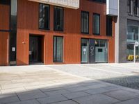 a man sitting on a bench in front of a building with wooden floors and red walls