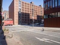 an empty city street with buildings and a truck on the side of it next to rocks