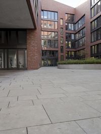 an empty floor in front of brick building with glass windows with an open patio to the side