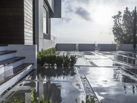 a view of the outside patio of an apartment building with tile floors and a bench