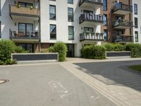 apartment buildings in urban area with parking space on sidewalk and trees along street near street curb