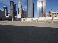 a parking lot with buildings in the background and sunlight reflecting off it's windows