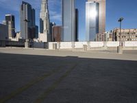 a parking lot with buildings in the background and sunlight reflecting off it's windows