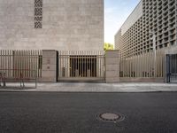 the building has a large gate on the street corner and it's next to a bench