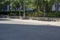 a car driving down an empty street lined with tall buildings and trees in the background