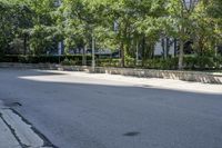 a car driving down an empty street lined with tall buildings and trees in the background