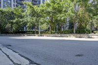 a car driving down an empty street lined with tall buildings and trees in the background