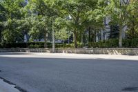 a car driving down an empty street lined with tall buildings and trees in the background