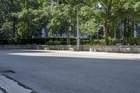 a car driving down an empty street lined with tall buildings and trees in the background