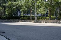 a car driving down an empty street lined with tall buildings and trees in the background