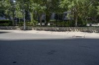 a car driving down an empty street lined with tall buildings and trees in the background