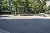 a car driving down an empty street lined with tall buildings and trees in the background