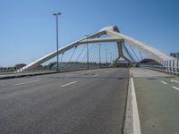 a truck driving across a bridge near a street corner near buildings and a bridge with many cables