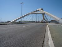 a truck driving across a bridge near a street corner near buildings and a bridge with many cables