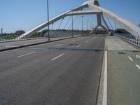 a truck driving across a bridge near a street corner near buildings and a bridge with many cables