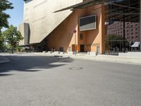 the large building has windows and many trees in front of it at the entrance to the museum