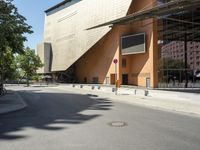 the large building has windows and many trees in front of it at the entrance to the museum