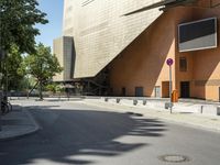 the large building has windows and many trees in front of it at the entrance to the museum