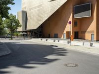 the large building has windows and many trees in front of it at the entrance to the museum