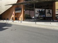 the large building has windows and many trees in front of it at the entrance to the museum