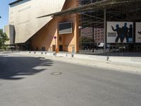 the large building has windows and many trees in front of it at the entrance to the museum