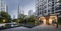 a nice courtyard area in the city with a pond and patio furniture set next to the water feature