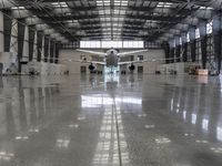 an image of a large hangar with two planes inside it or in the building on one side, and others standing outside