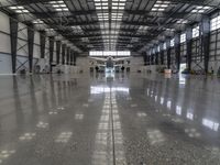 an image of a large hangar with two planes inside it or in the building on one side, and others standing outside