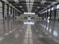 an image of a large hangar with two planes inside it or in the building on one side, and others standing outside