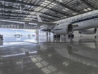 a white plane parked inside of a hanger in an hanger with an ocean