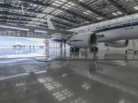 a white plane parked inside of a hanger in an hanger with an ocean