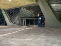 the entrance to an airport with stairs leading up to it and a large glass wall