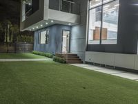 the outside of an apartment that has artificial grass and artificial lighting on it's side