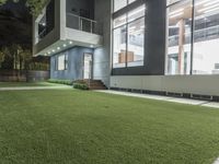 the outside of an apartment that has artificial grass and artificial lighting on it's side