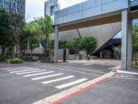 a empty street with a red curb on each side of it with an unusual modern building behind it