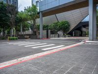 a empty street with a red curb on each side of it with an unusual modern building behind it