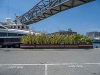 a boat is parked in a parking lot near the harbor and bridge and other boats