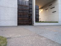 the entrance to an office building with large windows and stairs leading up to it that leads to a covered area in the center