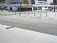 a skateboarder rides his board on the concrete street in front of a building