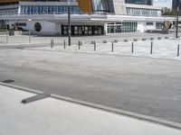 a skateboarder rides his board on the concrete street in front of a building