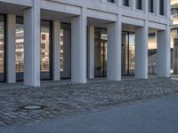 the large office building is located in the center of a cobblestone plaza of the city