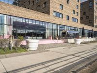 a building with a walkway and lawn area in front of it along a city street